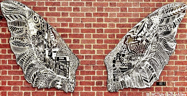 Wings art exhibit on brick wall
