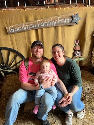 Couple holding baby posing for photo.