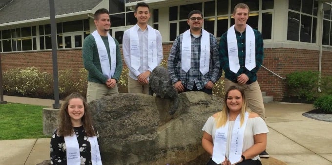 Six students (four standing, two seated) posed with Bruiser Bobcat statue