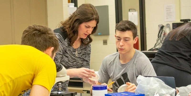 Faculty member and student examining petri dish