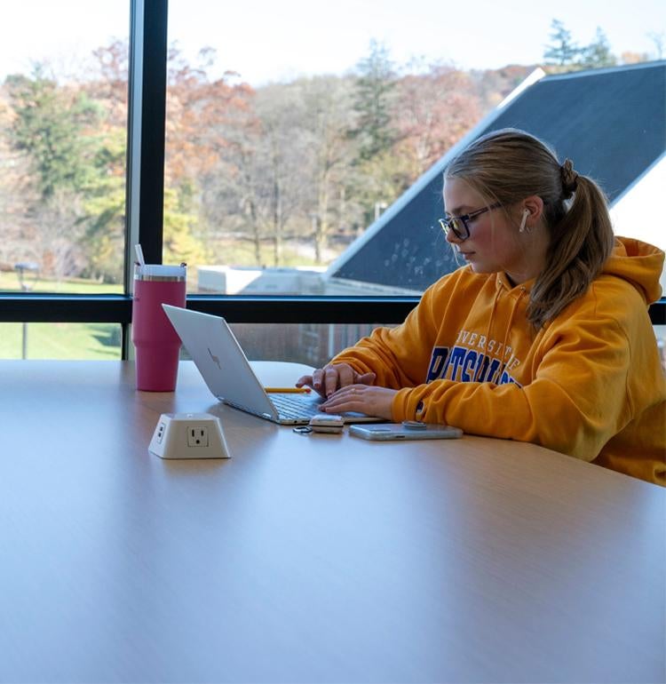 A student does homework in a Greensburg Campus study space.